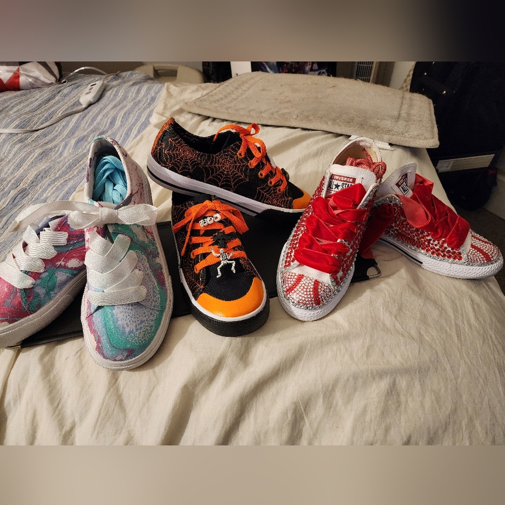 Three pairs of custom sneakers, all different sizes.